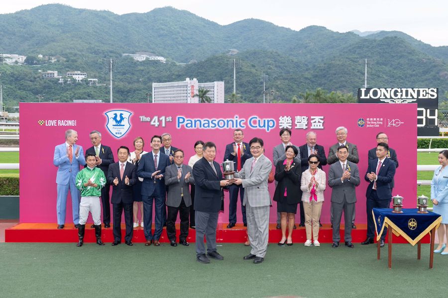 Panasonic Holdings Corporation 集團副總裁本間哲朗先生（右）將「樂聲盃」獎盃頒予「堅又威」的馬主堅又威賽馬團體（左）。